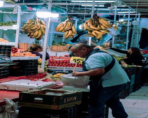 Person buying fruit at a local neighborhood store in Colombia